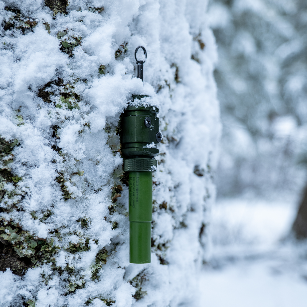 [Fith Ops Gen4 2-in-1 Rescue Tool Set up as a perimeter trip alarm on a snowy tree]]